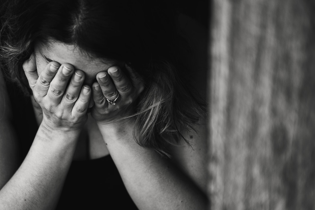 Imagen de una mujer tapándose la cara, deprimida, depresión, tristeza, luego del parto, post parto, depresión