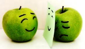 En esta foto se ven dos manzanas verdes, la una sonreída viéndose al espejo, la otra detrás del espejo triste, el contraste y ser alguien que no esté triste. Busquemos coherencia, ayuda terapéutica, psicóloga ecuador, psicóloga quito, terapia psicológica, ayuda